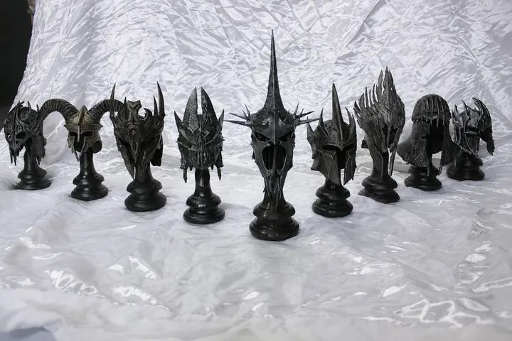 Niz tamnih fantasy kaciga na crnim postoljima