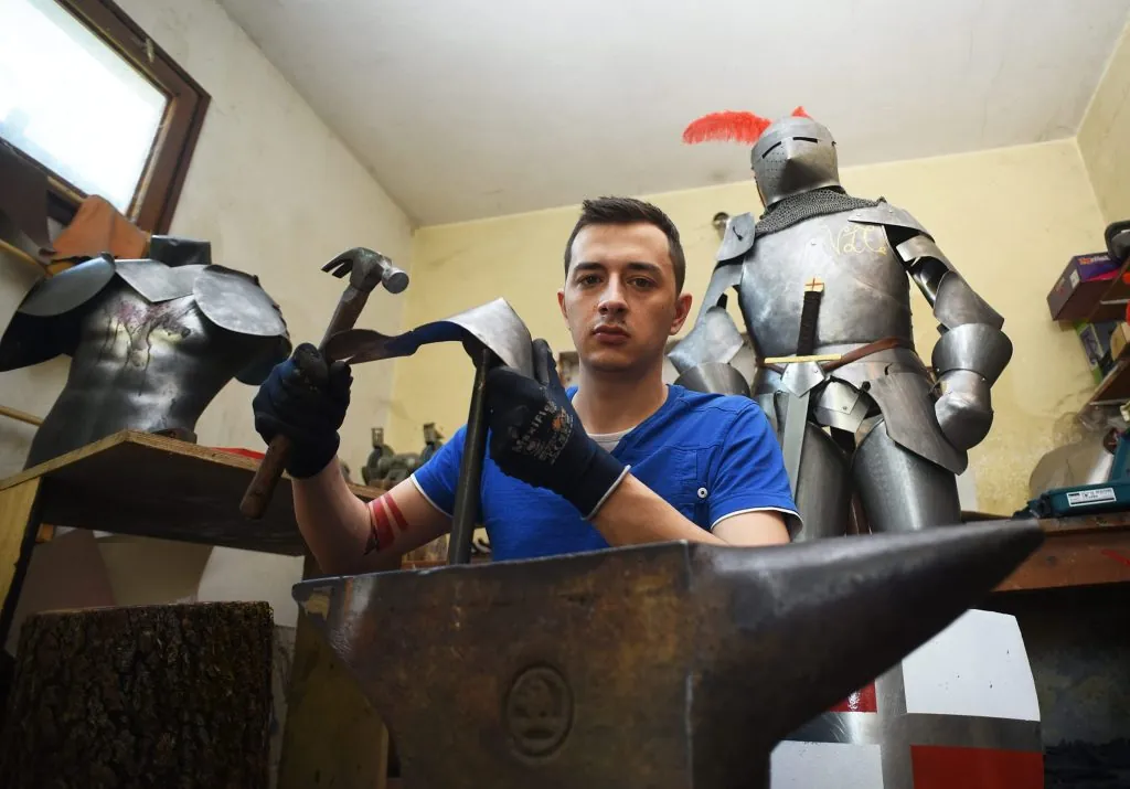 Pavel Butolen oblikuje metalnu ploču na nakovnju