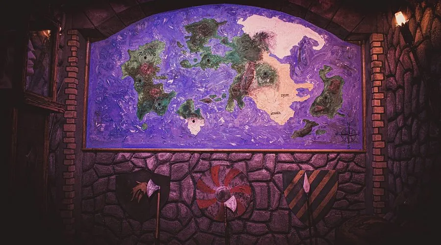 Zid s ručno izrađenom fantasy kartom svijeta, štitovima i sjekirama